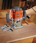 Workhorse Plunge Wood Router With Edge Guide 110 120V 1.6 HP Motor Variable Speed 16000 30000 RPM Durable Electric Router For Precision Cutting And Edge Shaping in use on a workbench