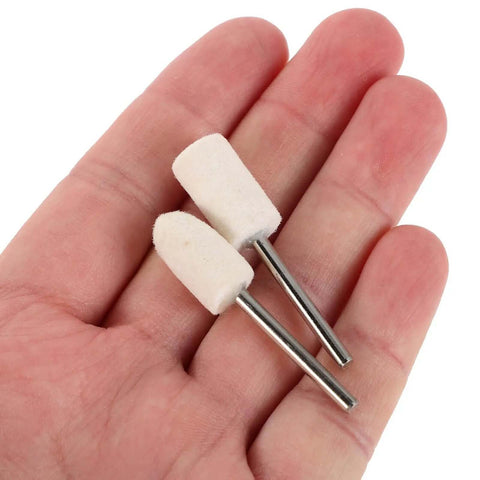 Hand holding two wool felt polishing wheels with 1/8 inch shank, part of the 40 Piece Wool Felt Polishing Wheel Set With One Eighth Inch Shank For Drill Buffing Attachments Ideal For Jewelry Wood And Metal Finishing Cylinders And Tapered Polisher Attachments.