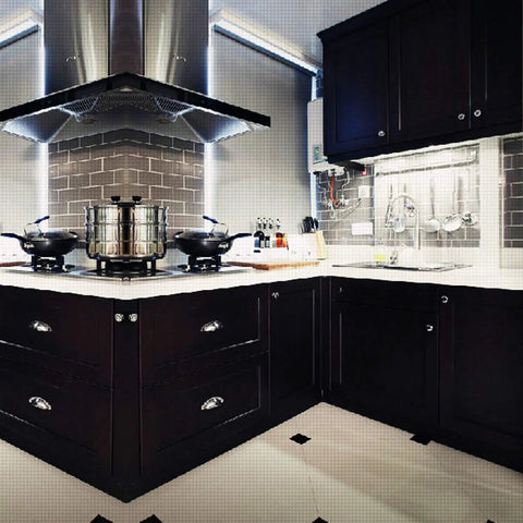 Modern kitchen with dark cabinets and stainless steel appliances, under sleek exhaust hood.
