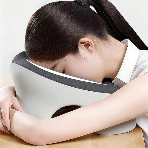 Woman using Desk Napping Pillow With Memory Foam Headrest For Office And Travel, super comfy and portable, light gray.