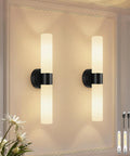 Rechargeable Wall Sconces Set of Two, Modern Matte Battery Operated Wall Light Fixtures with Remote Control, Dimmable Wireless Wall Sconces with Milky Glass for Bathroom Mirror Bedroom Living Room on a wall with glowing lights.