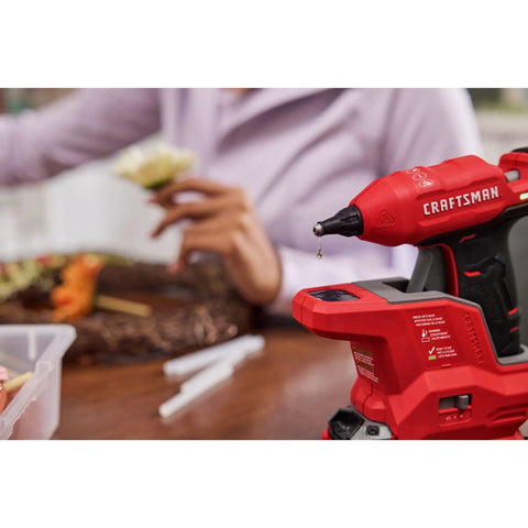 Red V20 Mini Cordless Hot Glue Gun with LED Light on table, person crafting in background, Fast Heat Up, Dual Temp Control, Cordless DIY Tool.