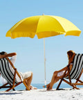 Two people sit under a yellow umbrella on the beach, secured with Heavy Duty Beach Umbrella Sand Anchor Base With 5 Spiral Screw Design.