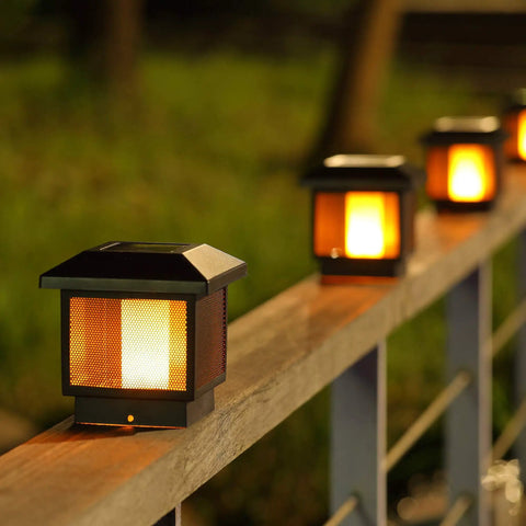Two Pack Solar Flame Post Lights With 72 LED Flickering Flame Outdoor Cap Lights on wooden fence at night