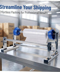 Manual Stretch Film Dispenser Stand For Shipping Supplies Hand Operated Wrap Film Holder With Metal And Plastic Construction Lightweight Yet Sturdy For Easy Desktop Wrapping And Efficient Warehouse Or Home Packing on a metal table