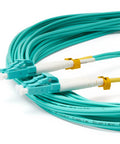 Close-up of LC to LC OM4 fiber patch cable, 3 m, duplex multimode, aqua with white booted connectors