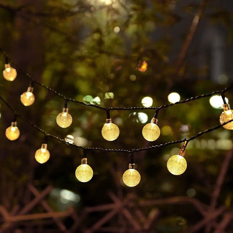 Battery Operated Globe Fairy Lights 16 Feet Waterproof With Timer And 8 Modes 30 LEDs Warm White Indoor Outdoor Decor For Patio Garden Christmas Tree 2 Pack Create Cozy Vibes glowing at night in garden setting.