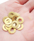 Close-up of a hand holding EDC Pocket Knife Brass Washer Set For Pivot Pins 20 Pcs Replacement Gaskets For C81 C223 C85.