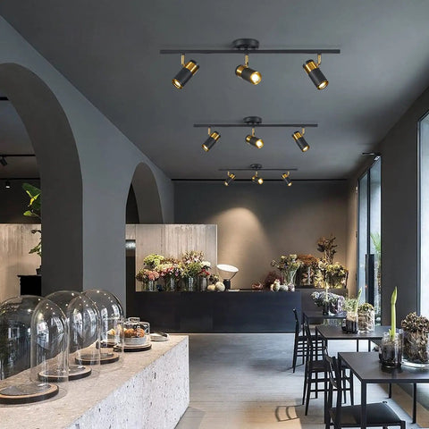 Three Light Black Track Lighting With Rotatable Heads GU10 Ceiling Spotlights illuminating a modern living room.