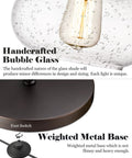 Farmhouse Bubble Glass Floor Lamp With Adjustable Tall Pole, close-up of bubble glass shade and weighted metal base with foot switch.