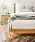 Bedroom with beige bed, oak bedside table, and decor, showcasing bed with Set of 4 Solid Wood Tapered Sofa Legs With M10 Bolt Replacement.