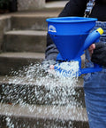 Person using Spyker Pro Series 50 Pound Broadcast Spreader With 5 Pound Handheld Spreader Kit for ice melt on stairs