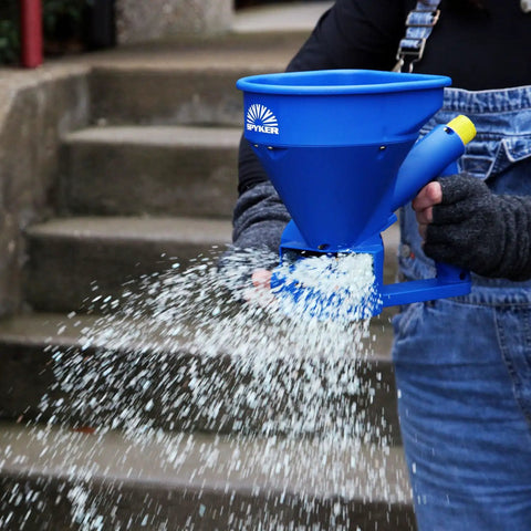 Person using Spyker Pro Series 50 Pound Broadcast Spreader With 5 Pound Handheld Spreader Kit for ice melt on stairs