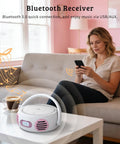 All In One Portable Boombox CD Player With Bluetooth for home use on a coffee table next to a woman using a smartphone.