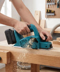 Heavy Duty Cordless Hand Planer With A Beefy 15000 RPM Brushless Motor, Slick Two Millimeter Cut Depth, And Tough Carbide Blades For Fast Wood Surfacing in use on wood.