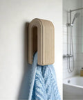 Premium Wall Mount Automatic Locking Towel Hook With Smart Space Saving Design And No Sweat Storage For Daily Grind In Slick Matte Black Finish For Any Modern Setup holding a blue towel.