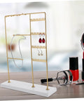 Spin Your Daily Drip Easily With This Smooth Rotating Jewelry Tree Stand Constructed From Premium Iron And Solid Marble For Necklaces And Earrings Storage, gold iron stand displaying earrings and necklaces.