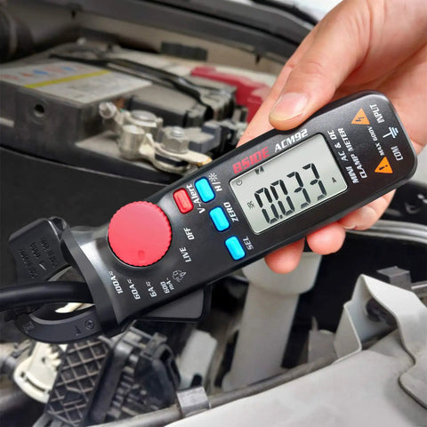 Person using Mini Clamp Meter For AC And DC Current Up To 100 Amp, Auto Range Digital Multimeter with Frequency Tester on car