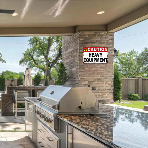 Caution Heavy Equipment Safety Sign With Funny Aluminum Wall Decor, 8x12 Inch, outdoors on a brick wall near a grill area.