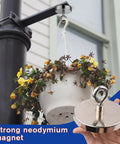 Beast Mode Neodymium Fishing Magnet With 1500 Lb Pulling Force used to hang a flower pot, demonstrating strength and size.