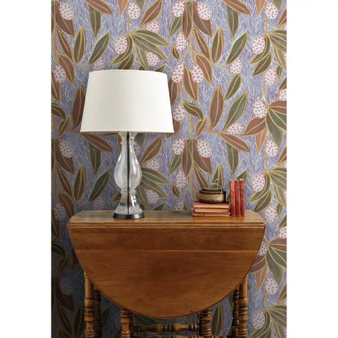 Hand Drawn Botanical Wallpaper With Slick Matte Linen Finish, showcasing purple floral design behind a wooden table and lamp.