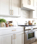Kitchen with Champagne Bronze Cabinet Pulls 5 Inch 128mm Solid Zinc Alloy Handles installed on white cabinets and drawers.