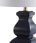 Close-up of modern footed vase base of navy blue and gold ceramic table lamp with white linen shade, LED bulb included, UL listed.