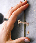 Hand using Heavy Duty Hollow Wall Anchor Kit with Spiral Design Screws for drywall installation