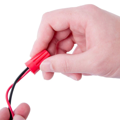 Hand holding red WireGard Screw On Wire Connector Assortment 22 To 8 AWG 25 Pack Electrical Wire Nuts for Home DIY and Pro
