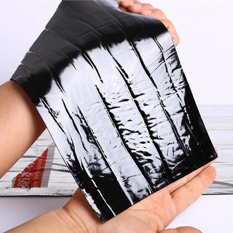 Heavy Duty Black Asphalt Crack Repair Tape held in hand, waterproof self adhesive roll, ideal for sealing roofs and decks.