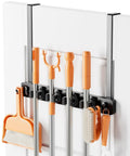 No Drill Over The Door Mop And Broom Holder With Four Slots And Four Hooks Wood Tool Hanger installed over white door holding cleaning tools