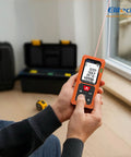 165ft Laser Tape Measure With Bubble Level for Quick, Pro Grade Accuracy and Easy Room Measurements, Digital Distance Tool for Home DIY, Renovations, and Construction Projects orange handheld laser meter measuring room by window