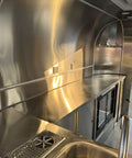 Interior view of Rock Solid Heavy Duty Mobile Coffee Concession Cart With Spacious Storage Compartments featuring stainless steel counters.
