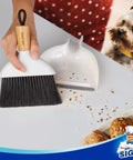 Hand using Grab And Go Mini Dustpan And Brush Set With Bamboo Handle, Portable Handheld Cleaning Kit, Eco Friendly Bamboo Dustpan And Brush Combo, Dense Soft Bristles That Wont Scratch Surfaces, Rubber Lip Guard, 1 Set, cleaning spilled crumbs on a countertop.