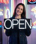 Person holding a Lit White Neon Open Sign With Remote For Business Front Window Display 20x7 Inch LED Light Up Sign