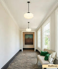 puncoll Vintage Black Milk Glass Pendant Light, 15.7'' White Chandelier illuminating a modern hallway with a stylish décor.