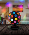 Spinning 11 Inch Disco Ball With LED Lights And 360 Degree Rotation for parties on a wooden table illuminating room with colorful lights