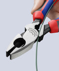 Close-up of KNIPEX 9.5-inch ultra-high-leverage lineman's pliers with fish tape puller and crimper, red/blue handles