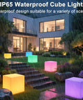 Lit RGB Color Changing LED Cube Seat 14-Inch LED Cube Chair illuminating garden steps in rain, showcasing waterproof feature