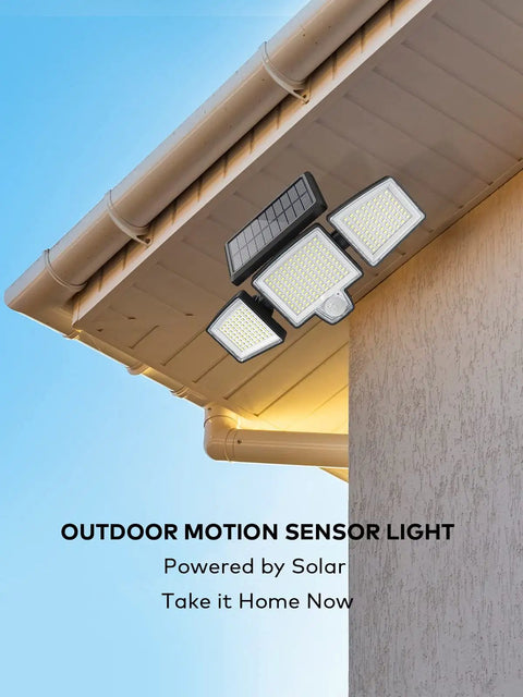 Solar Motion Sensor Outdoor Flood Lights With Remote Control, mounted on a house, showcasing 3 heads and solar panel.