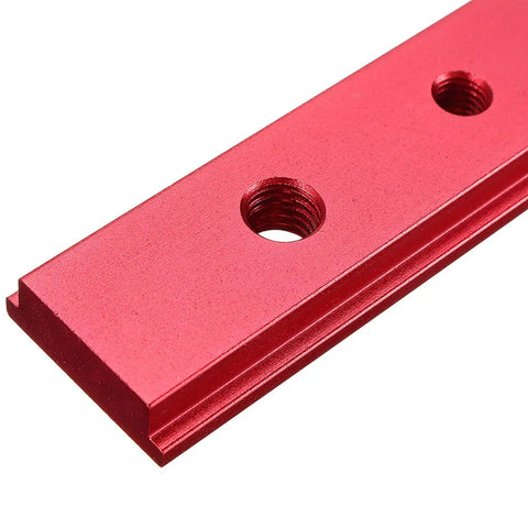 Close-up of red anodized heavy duty aluminum miter bar slider for T slot table saw track setup rod, showing threaded holes.