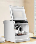 Fully Automatic Compact Desktop Dishwasher For Six Person Households on a kitchen countertop with clean plates and cups.