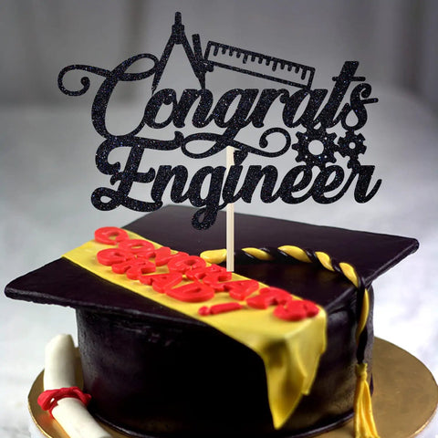Engineer Graduation Cake Topper For Class Of 2026 on chocolate cake with cap and scroll, black glitter cardstock, engineering grad decor.