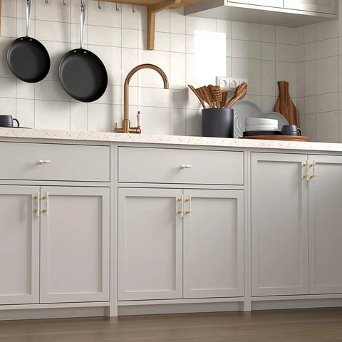 Modern kitchen cabinetry featuring Ten Pack Center Mount Cabinet Knobs And Barrel Drawer Pulls In Matte Black With Gold Accents.