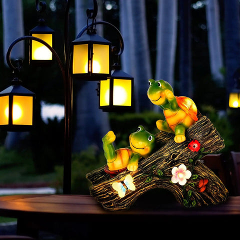 Two playful turtles on a log with lanterns in the background, suitable for outdoor garden decor to add cute vibes day or night.