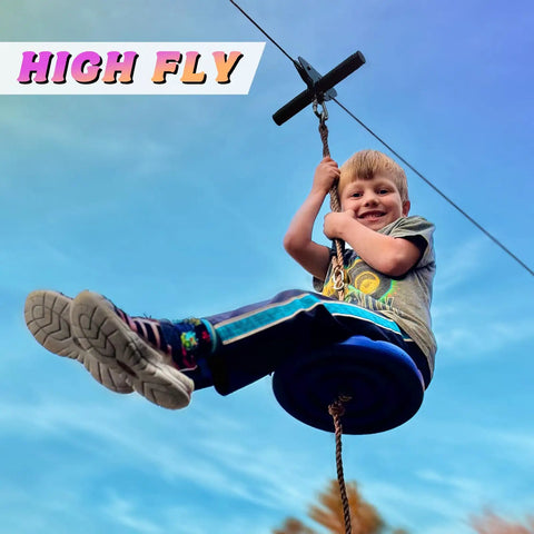 Child enjoying Backyard Zipline Kit For Kids And Adults With Stainless Steel Spring Brake, seen riding with a safety harness.