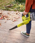No Sweat Heavy Duty 18V Cordless Yard Leaf Blower With Comfy Overmold Grip cleaning leaves off a wooden patio.