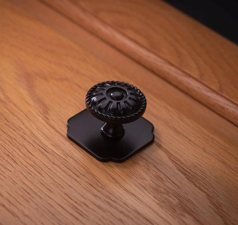 9 Pack Matte Black Cabinet Knobs 1.25 Inch Round Zinc Pulls With Victorian Floral Pattern for farmhouse kitchens on wooden surface