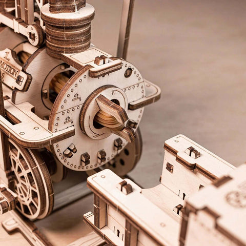 Front view of a wooden mechanical model with gears, wheels and lever, unfinished basswood construction