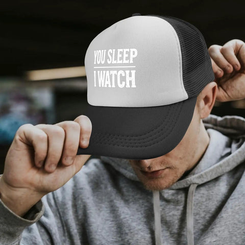 All Day Comfort Mens Breathable Golf Trucker Hat with front artwork "You Sleep I Watch" in outdoor casual style